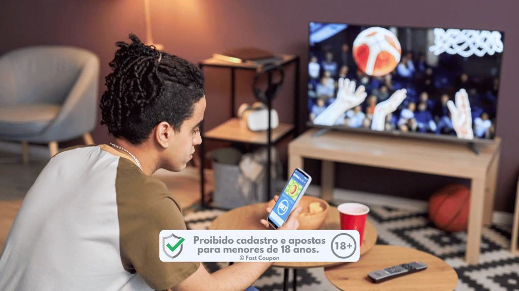 Uma bola de basquete na quadra, com um smartphone mostrando a tela de apostas.